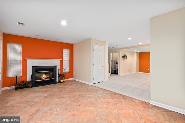 living room with visible vents, a fireplace with flush hearth, light carpet, recessed lighting, and baseboards