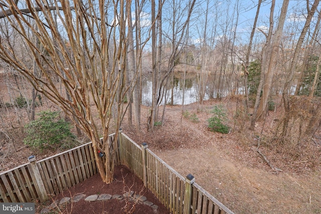 view of yard featuring a water view and a fenced backyard