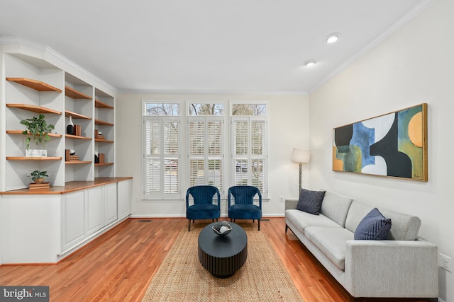 living room featuring baseboards, light wood-style floors, and ornamental molding