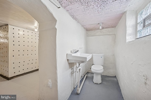 bathroom featuring toilet and concrete flooring