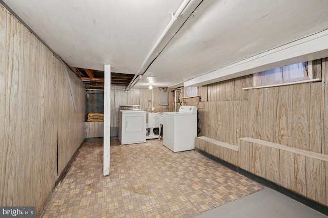 finished basement featuring independent washer and dryer and wood walls