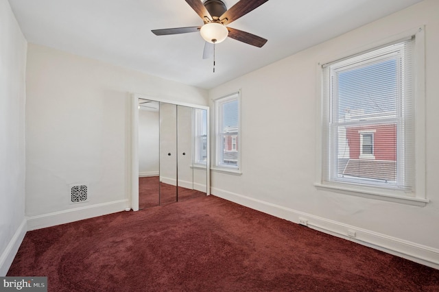 unfurnished bedroom featuring visible vents, ceiling fan, baseboards, carpet, and a closet