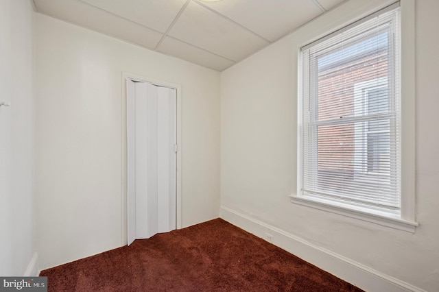 carpeted spare room with a paneled ceiling