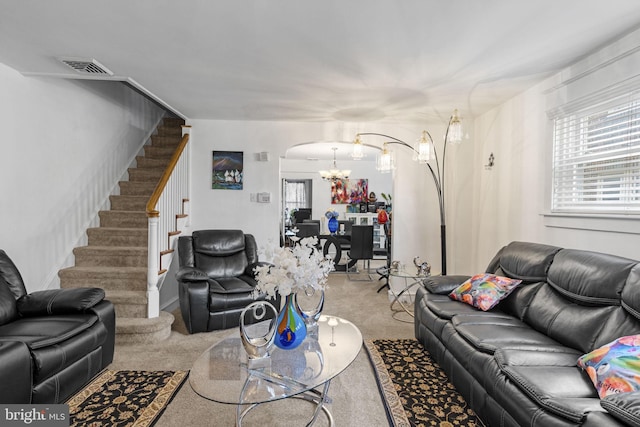 living room with visible vents, arched walkways, carpet flooring, a chandelier, and stairs