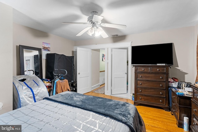 bedroom featuring light wood-type flooring, visible vents, and ceiling fan