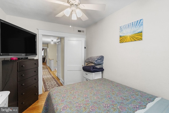 bedroom with visible vents, a ceiling fan, and light wood-style floors