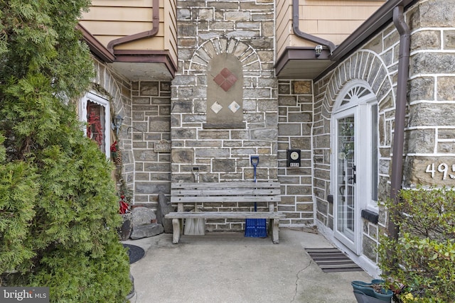 property entrance featuring stone siding