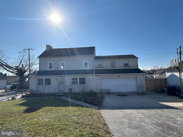 view of front of property with fence, driveway, stucco siding, a front lawn, and a garage