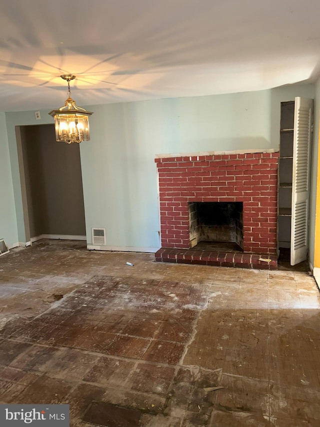 unfurnished living room with visible vents, a chandelier, and a fireplace