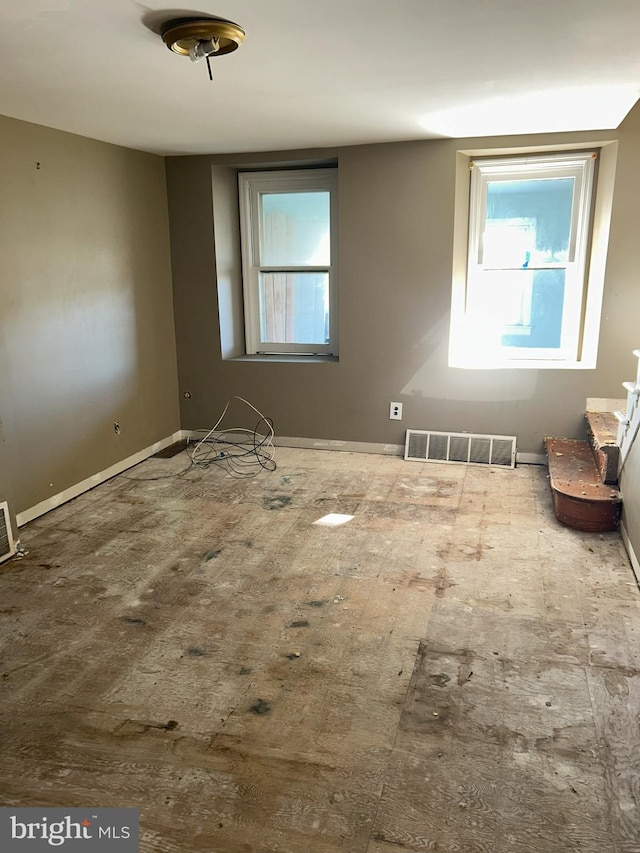 unfurnished room with visible vents and baseboards