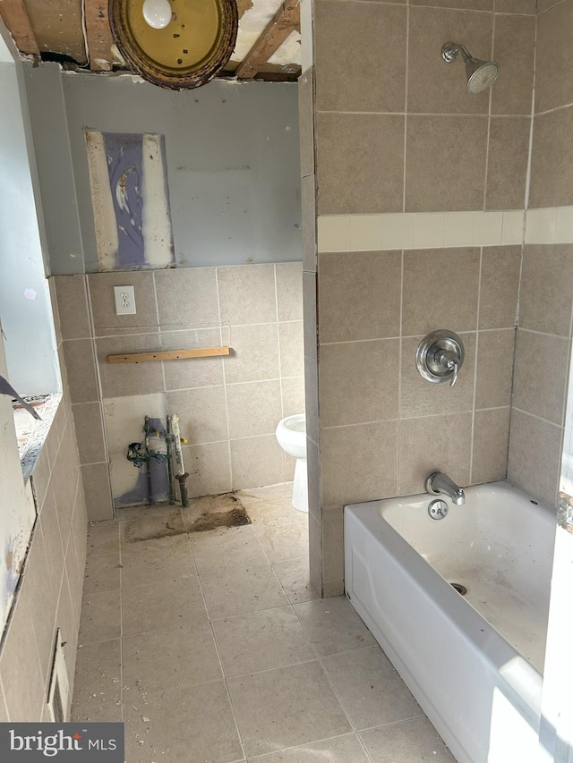 bathroom featuring tile patterned flooring, tile walls, and bathtub / shower combination