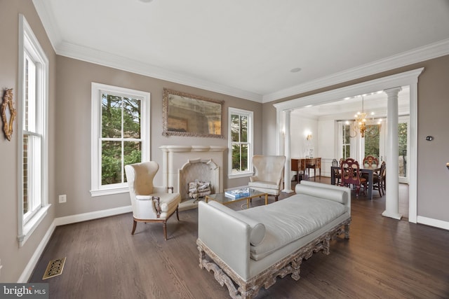 sitting room featuring wood finished floors, visible vents, ornate columns, and baseboards