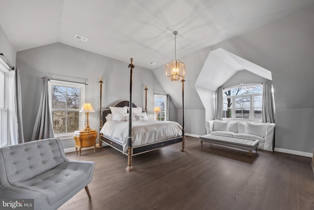 bedroom featuring visible vents, multiple windows, wood finished floors, and vaulted ceiling