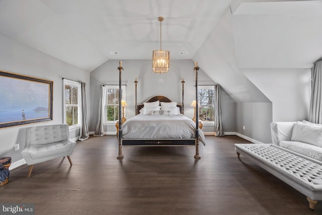 bedroom featuring baseboards, lofted ceiling, visible vents, and wood finished floors