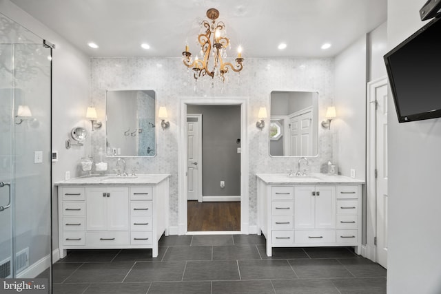 bathroom with a stall shower, two vanities, and a sink