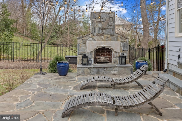 view of patio with an outdoor stone fireplace and a fenced backyard