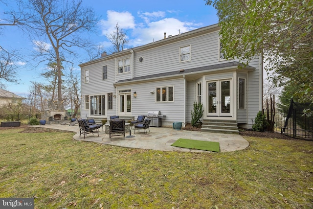 back of property with a lawn, french doors, a patio, and fence