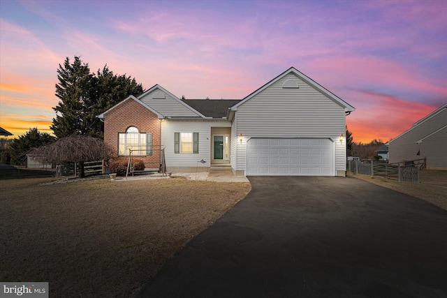 ranch-style house with fence and aphalt driveway