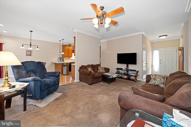 living area featuring light carpet, baseboards, ornamental molding, and a ceiling fan