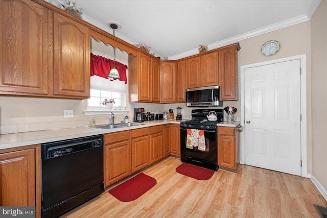 kitchen featuring black appliances, brown cabinets, and a sink