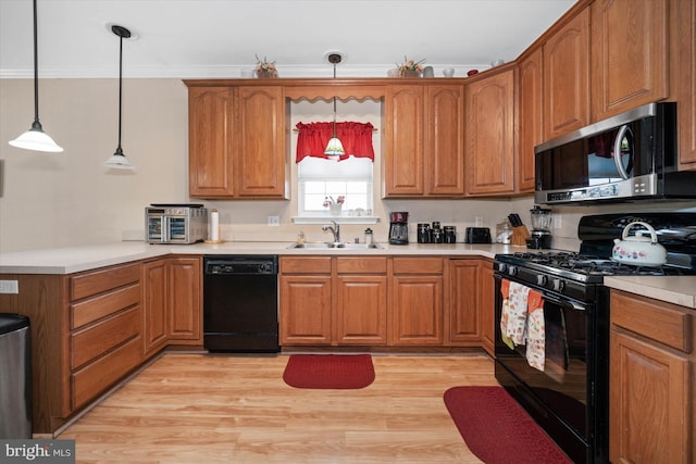 kitchen featuring black appliances, brown cabinetry, and a sink