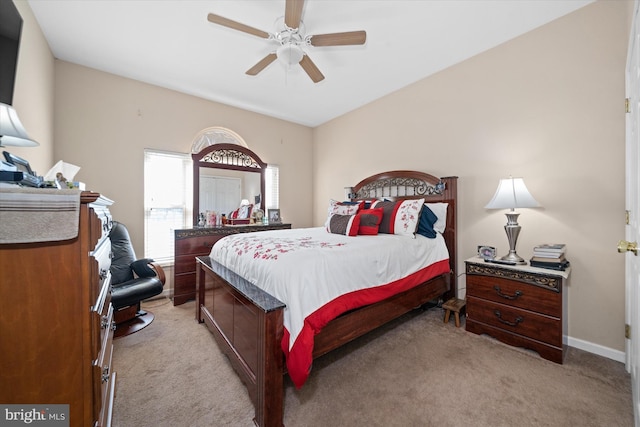 bedroom featuring light carpet, ceiling fan, and baseboards