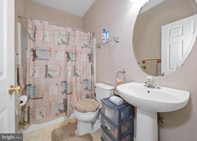 bathroom with curtained shower, toilet, and tile patterned floors