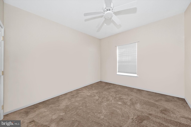 carpeted empty room with ceiling fan and baseboards