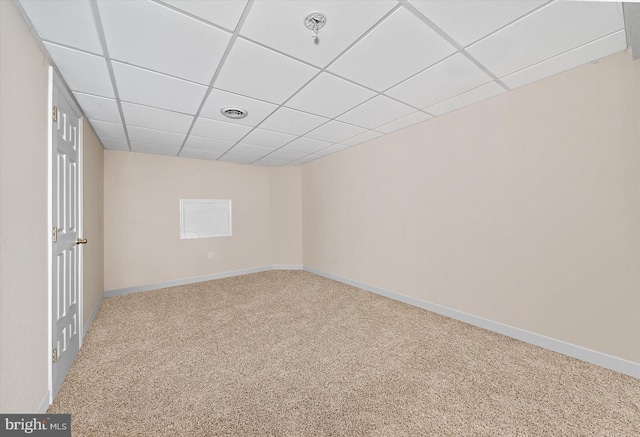 spare room featuring carpet floors, visible vents, baseboards, and a paneled ceiling