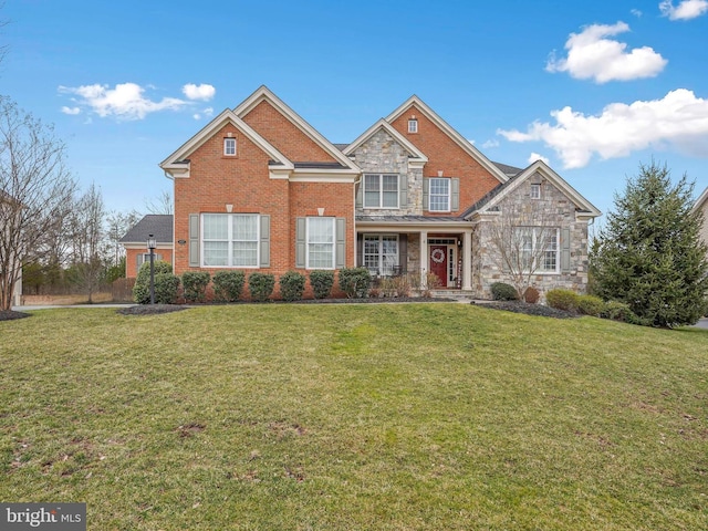 traditional home featuring a front yard, brick siding, and stone siding