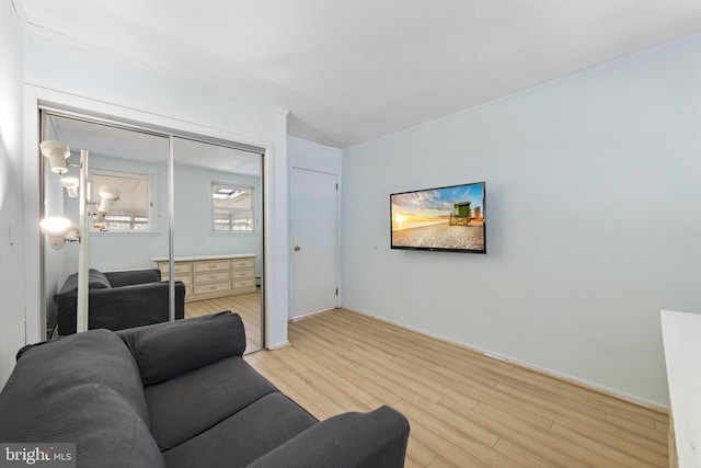 living room featuring light wood-style floors, baseboards, and ornamental molding