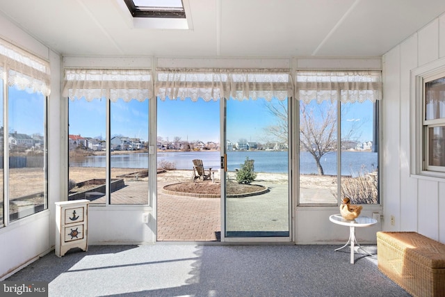 sunroom / solarium featuring plenty of natural light, a skylight, and a water view