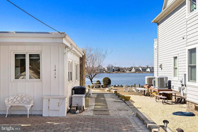 view of patio / terrace featuring cooling unit and a water view