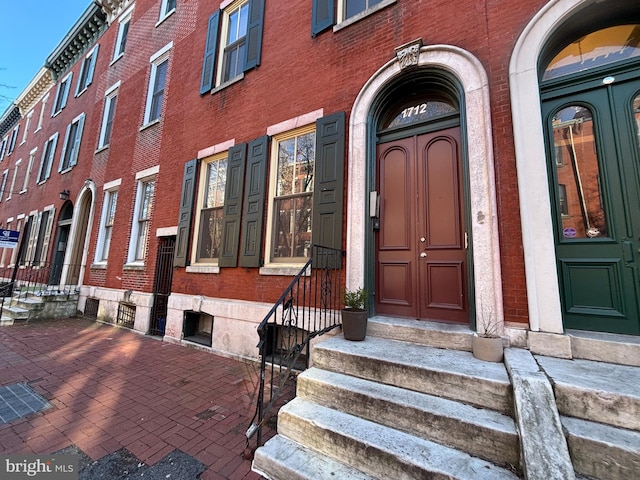 doorway to property featuring brick siding