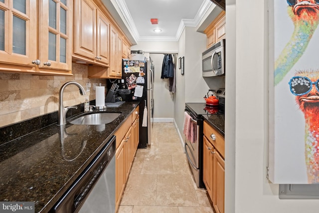 kitchen with crown molding, dark stone counters, decorative backsplash, stainless steel appliances, and a sink