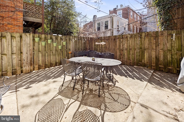 view of patio featuring outdoor dining area and fence