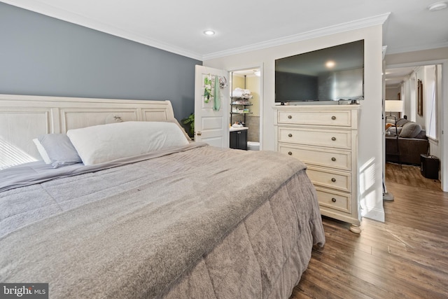 bedroom with dark wood-style floors, ensuite bathroom, and ornamental molding