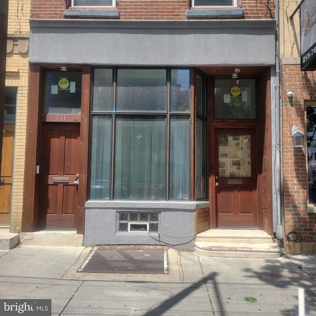 entrance to property featuring brick siding