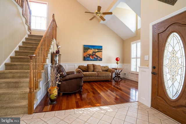 foyer entrance with tile patterned flooring, a wealth of natural light, and wainscoting