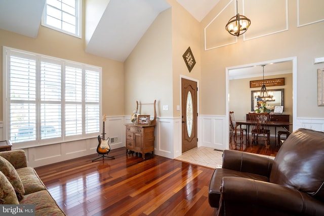 living room with visible vents, a wainscoted wall, hardwood / wood-style floors, and a chandelier