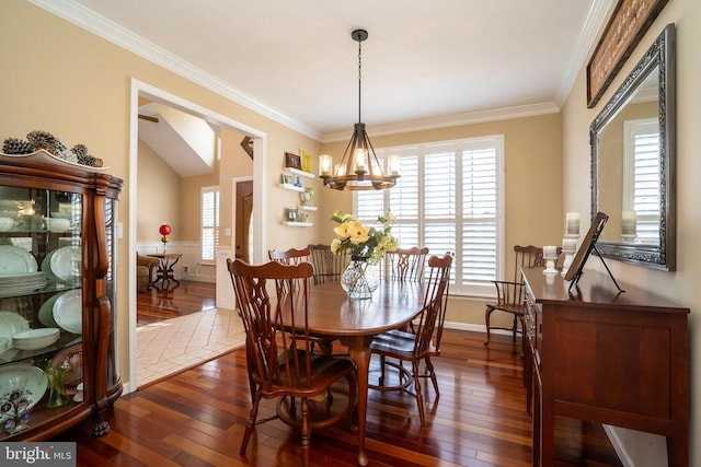 dining room featuring dark wood finished floors, crown molding, a notable chandelier, and baseboards