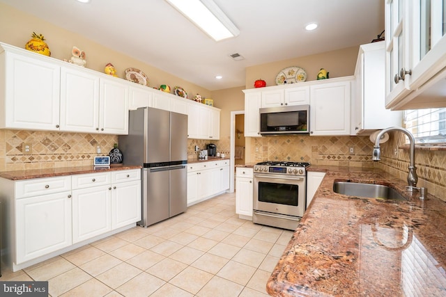 kitchen featuring visible vents, a sink, light stone counters, appliances with stainless steel finishes, and white cabinets