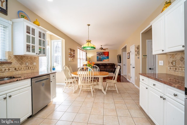 kitchen featuring light tile patterned floors, white cabinets, dishwasher, and dark stone countertops