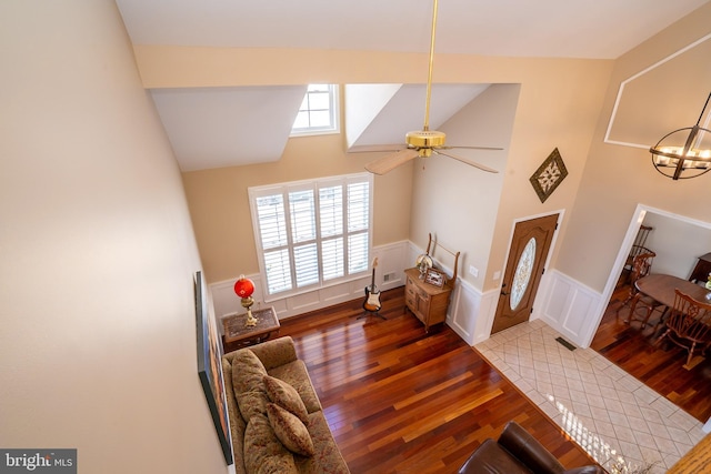 interior space with a wealth of natural light, a wainscoted wall, high vaulted ceiling, and wood finished floors