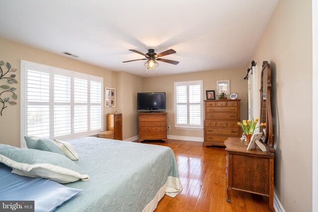 bedroom with visible vents, ceiling fan, baseboards, and light wood-style floors