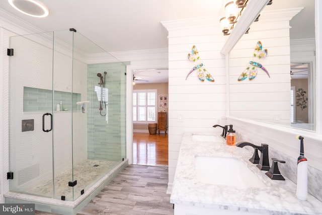 full bath featuring ornamental molding, a shower stall, ceiling fan, and a sink