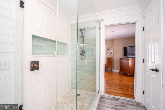 bathroom featuring a walk in shower, wood finished floors, and ornamental molding