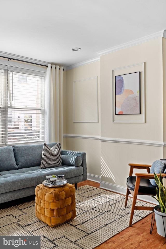 living room with crown molding, baseboards, and wood finished floors