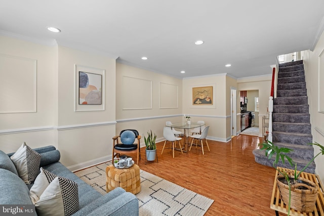 living area featuring baseboards, stairway, wood finished floors, and ornamental molding