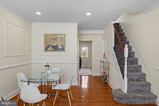 dining area featuring ornamental molding, baseboards, and wood finished floors